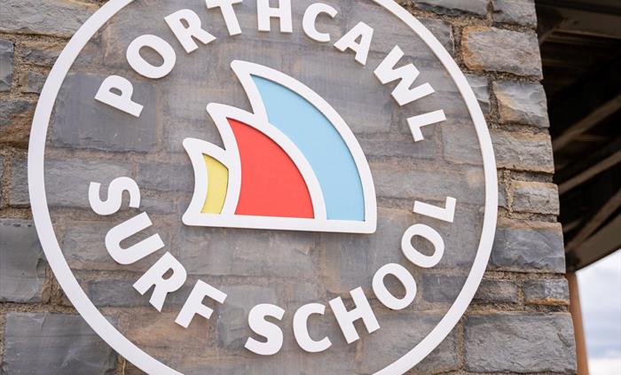 Image of surf school logo on a stone wall of a building.